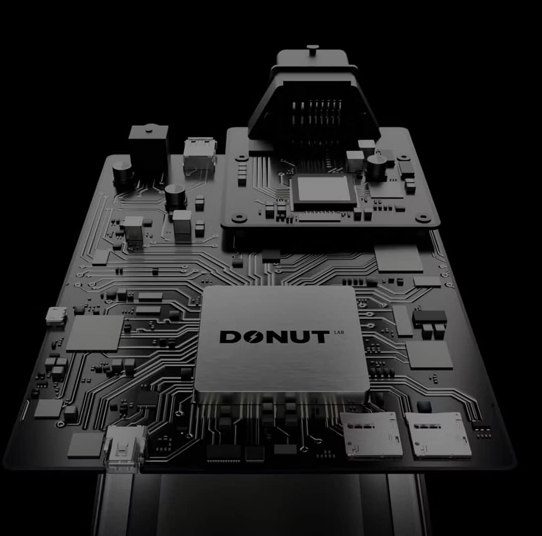 Close-up of a black computer circuit board with various electronic components, connectors, and chips. The central chip is labeled 